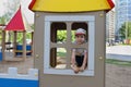 Little boy looks into window in wooden house Royalty Free Stock Photo