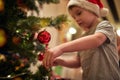 A little boy decorating a Christmas tree with his mother at home. Together, New Year, family, celebration Royalty Free Stock Photo