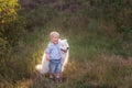 Little boy lovingly embraces white fluffy Samoyed dog. Friendship between man and animal. Traveling Royalty Free Stock Photo