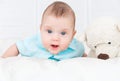 Little boy is lying on the bed next to a teddy bear Royalty Free Stock Photo