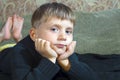 Little boy is lying on the couch and is looking at the camera Royalty Free Stock Photo