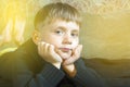 Little boy is lying on the couch and is looking at the camera. Picture with tint. Royalty Free Stock Photo
