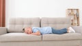 The little boy is lying on the couch, he wakes up and yawns with his arms outstretched Royalty Free Stock Photo