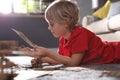 Little boy making cardboard toys on floor. Creative hobby Royalty Free Stock Photo