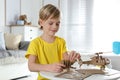 Little boy making carton toys at table. Creative hobby Royalty Free Stock Photo