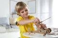 Little boy making carton toys at table. Creative hobby Royalty Free Stock Photo