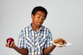 Little boy making decisions of eating healthy verses unhealthy.