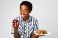 Little boy making decisions of eating healthy verses unhealthy. Royalty Free Stock Photo