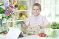 little boy making dinner on kitchen table with tablet at home Royalty Free Stock Photo