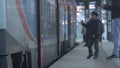 Little boy making farewells at railway station, waving hand to friend on a train