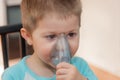 Little boy making inhalation with nebulizer at home. Close up portrait of boy