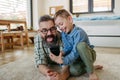 Little boy making selfie on smartphone with father, lying on floor in kids room, making silly faces. Dad explaining Royalty Free Stock Photo