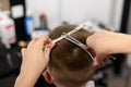 little boy in a mask, which is cut in the barbershop in the barbershop, fashionable and stylish haircut for a child. Royalty Free Stock Photo