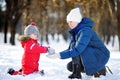 Little boy and middle age woman having fun with snow. Active outdoors family leisure with children in winter Royalty Free Stock Photo