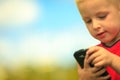 Little boy with mobile phone outdoor. Technology generation. Royalty Free Stock Photo