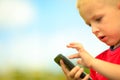 Little boy with mobile phone outdoor. Technology generation. Royalty Free Stock Photo