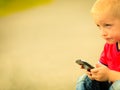 Little boy with mobile phone outdoor. Technology generation. Royalty Free Stock Photo