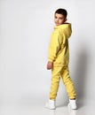 Little boy model in tracksuit with sweatshirt and pants. Portrait isolated on gray background. A male child poses for Royalty Free Stock Photo