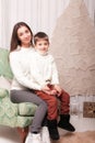 Little boy with mom posing in Christmas interior Royalty Free Stock Photo