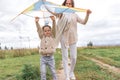 Little boy mom woman happy family, autumn day summer city park, launches kite airplane, laugh, smile, have fun, play Royalty Free Stock Photo