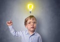 Little boy mull over with bulb above his head Royalty Free Stock Photo