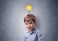 Little boy mull over with bulb above his head Royalty Free Stock Photo