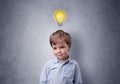 Little boy mull over with bulb above his head Royalty Free Stock Photo