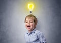 Little boy mull over with bulb above his head Royalty Free Stock Photo