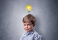 Little boy mull over with bulb above his head Royalty Free Stock Photo