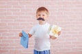 Little boy with a mustache holding a gift in his hands, father`s day, mother`s day Royalty Free Stock Photo