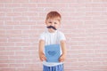 Little boy with a mustache holding a gift in his hands, father`s day, mother`s day Royalty Free Stock Photo