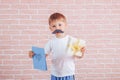 Little boy with a mustache holding a gift in his hands, father`s day, mother`s day Royalty Free Stock Photo