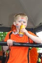 Young Dutch boy with orange t-shirt and flags on his face at Koningsdag (Kingsday),Netherlands