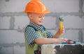 Little boy in orange protective helmet with instruments for renovation. Repair home. Royalty Free Stock Photo