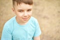 Little boy outdoor portrait. Happy baby face. Male person at backyard