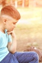 Little boy outdoor portrait. Serious baby face. Male person at backyard