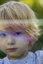 Young, 4 year old preschool boy with a grey shirt and blond hair, blowing bubbles in the yard Royalty Free Stock Photo