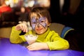 Little boy with painted face as butterfly, eating ice cream