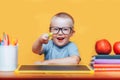 Little boy painting and doing homeworks on his desk having an idea, inspiration concept. back to school on yellow background Royalty Free Stock Photo