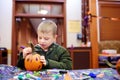 Little boy paints pumpkin on halloween party for children