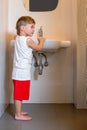 Little boy in pajamas stands in the bathroom