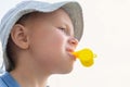 Little boy in a panama hat with a yellow whistle in his mouth Royalty Free Stock Photo