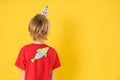 Little boy with paper fish on back against background, space for text. April fool`s day