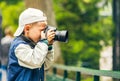 Little boy with photo camera makes a shoot