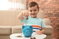 Little boy with piggy bank and money Royalty Free Stock Photo