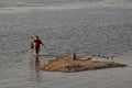 Little boy planting traditional fish trap in a shallow part of Mekong River, Ubon Ratchathani, Thailand