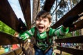 Little boy playing at rope adventure park. Summer holidays concept. Cute child having fun in net tunnel. Modern amusement park for Royalty Free Stock Photo