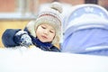 Little boy playing alone with toy in snow, close up. Outside, winter. Royalty Free Stock Photo