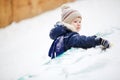 Little boy playing alone with toy in snow, close up. Outside, winter. Royalty Free Stock Photo