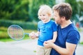 Little boy playing badminton with dad on the playground Royalty Free Stock Photo